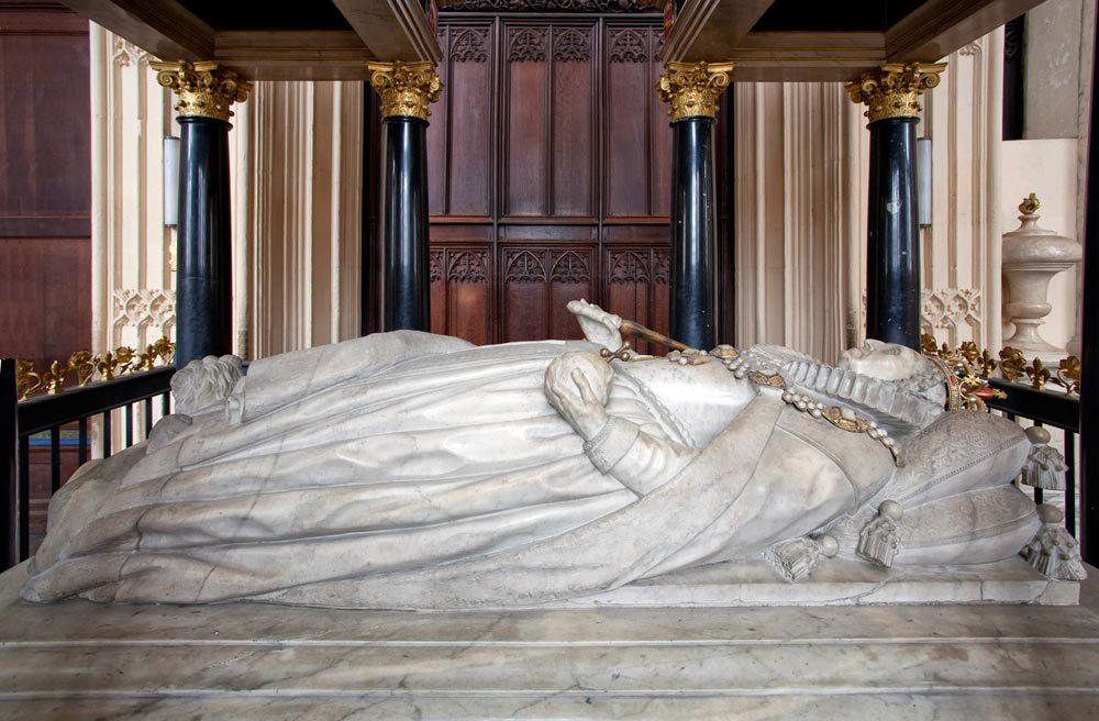 Reclining tomb effigy of Elizabeth I wearing a voluminous dress, her head resting on a pillow