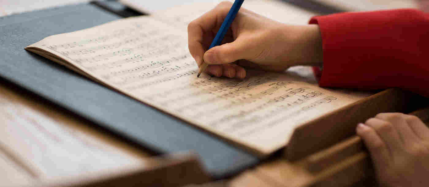 An Abbey chorister makes notes on a musical score