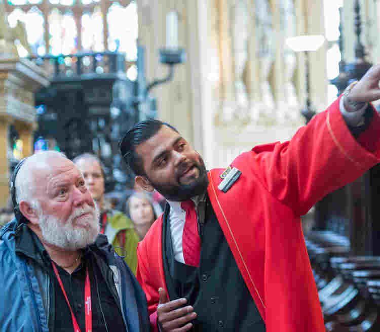 A member of the Visitor Experience team with a visitor pointing to something