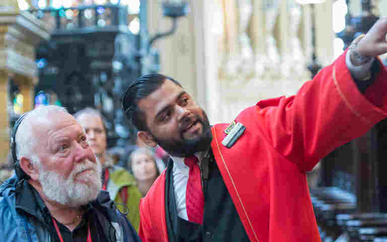 A member of the Visitor Experience team with a visitor pointing to something