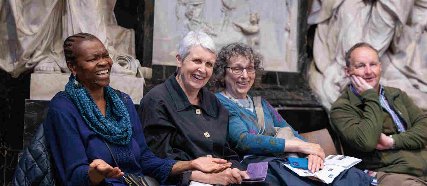 Photograph of seated members of the public laughing within Poets' Corner in Westminster Abbey