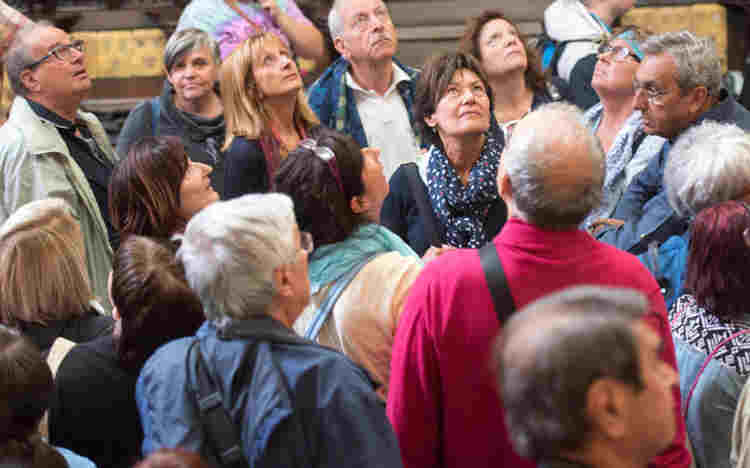 A tour group of around 20 people looks up at the ceiling of the Lady Chapel, Westminster Abbey