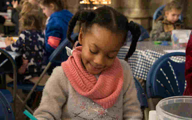 Photograph of young girl colouring in with felt tip pens, representing a Family Day activity at Westminster Abbey based on the Bayeux Tapestry as part of the Fraternite season