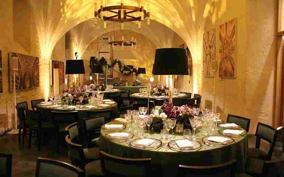 Round tables set up in the Cellarium, Westminster Abbey, for a corporate dinner