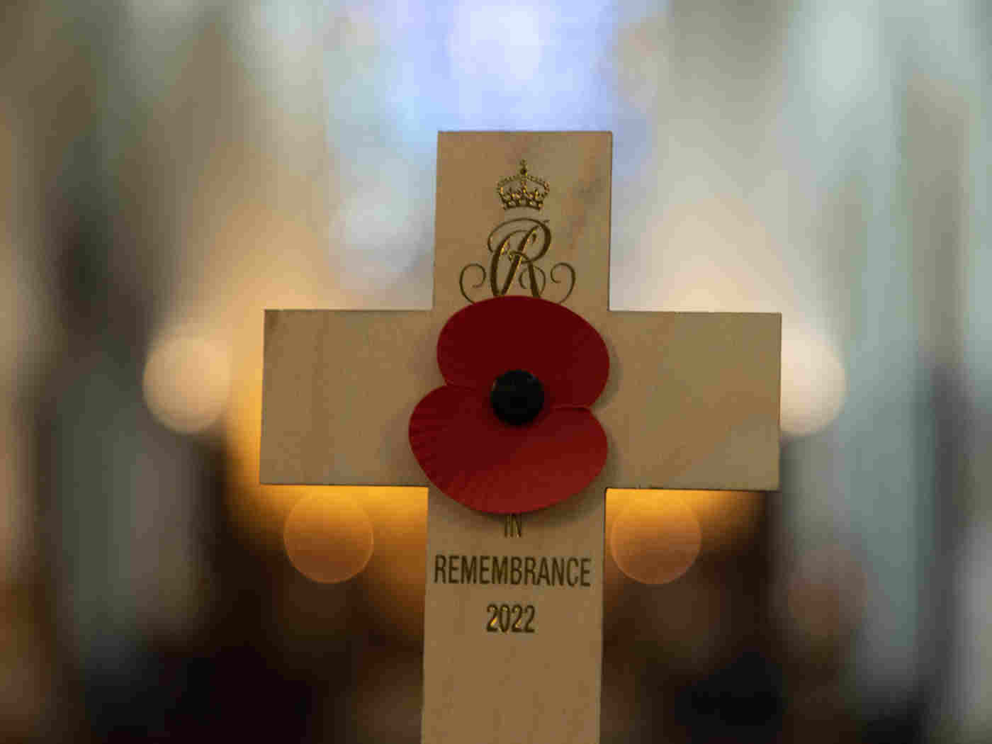 A wooden cross which features the Queen Consort's Royal cypher and an attached poppy
