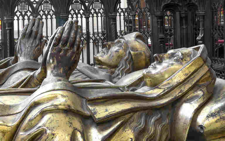 Close-up side-on photograph of the two effigies of Henry VII and Elizabeth of York above their tomb in the Lady Chapel of Westminster Abbey