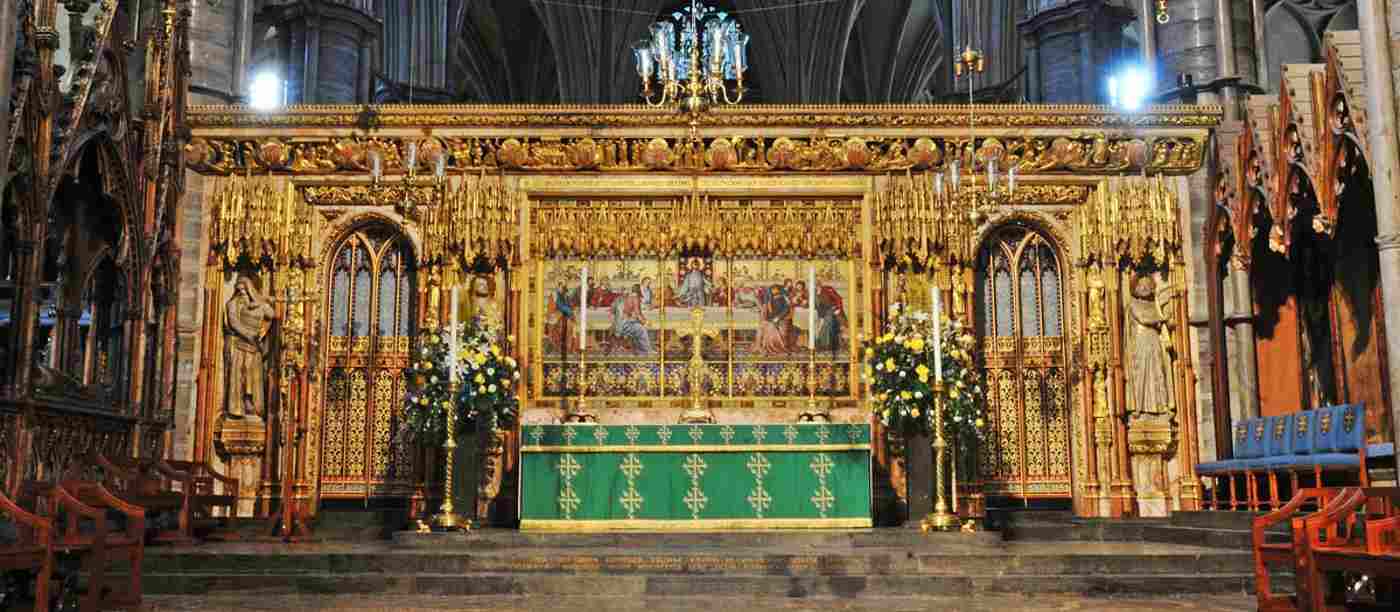 The high Altar on the Abbey. A gold-gilded panel is at the back and an altar and candlesticks appear in front.