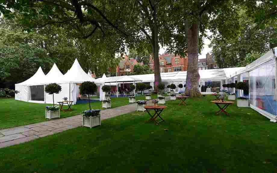 A marquee and tables and chairs arranged for a corporate event in Westminster Abbey's College Garden