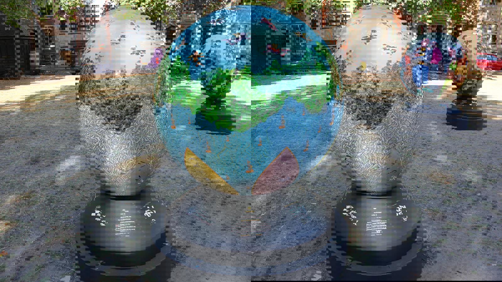 A large globe featuring a sea, tree and cherubs in the sky