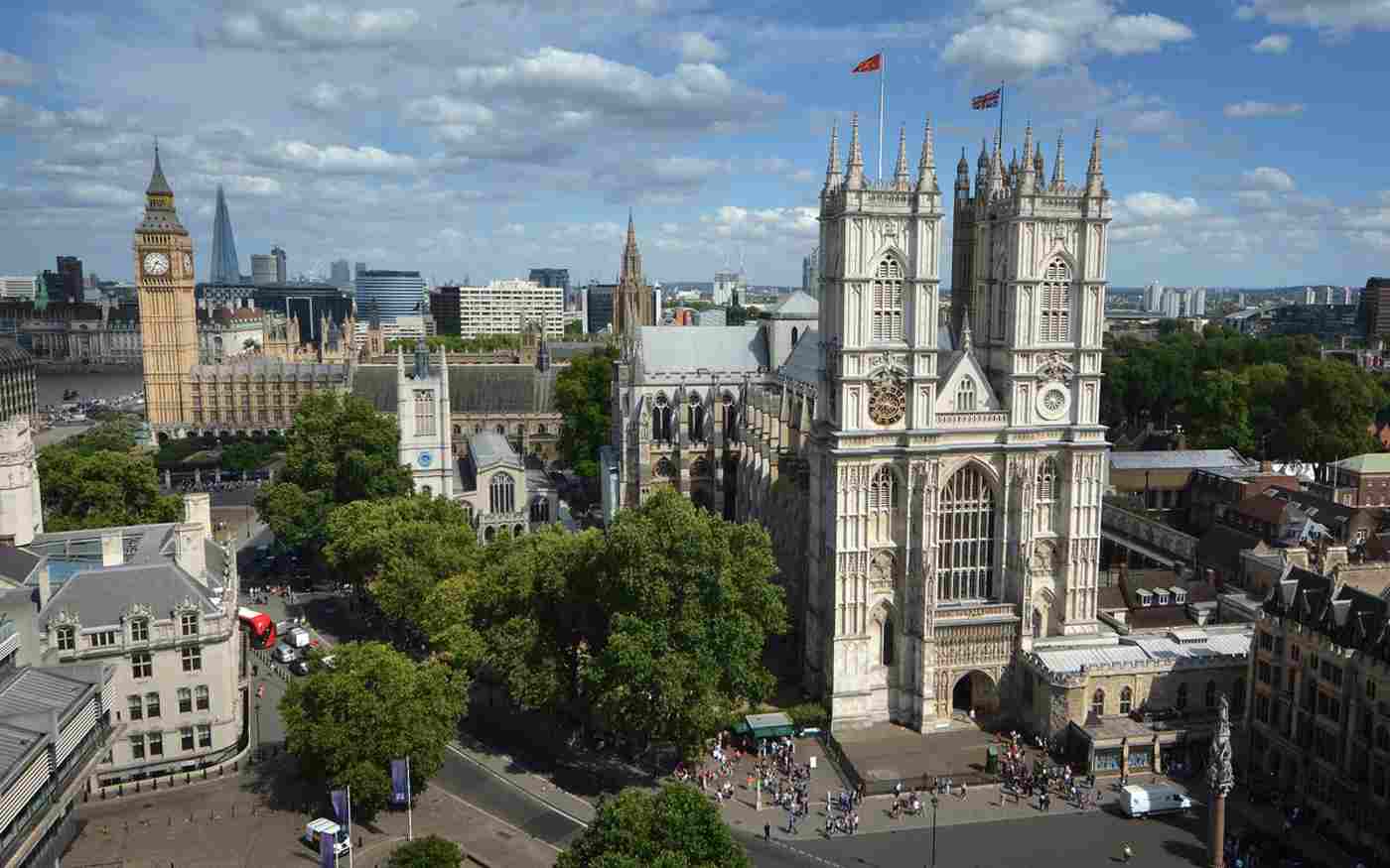 The West Front of Westminster Abbey on a sunny day. Big Ben can be seen in the background.