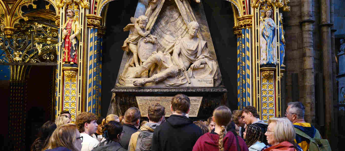 Photograph of group of people looking at one memorial within Westminster Abbey