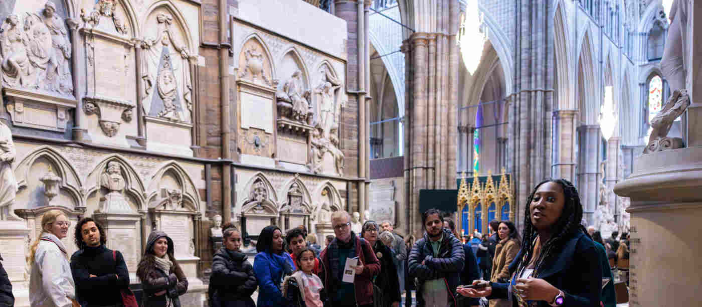 Photograph of adult speaking to a group of visitors within Poets' Corner in Westminster Abbey