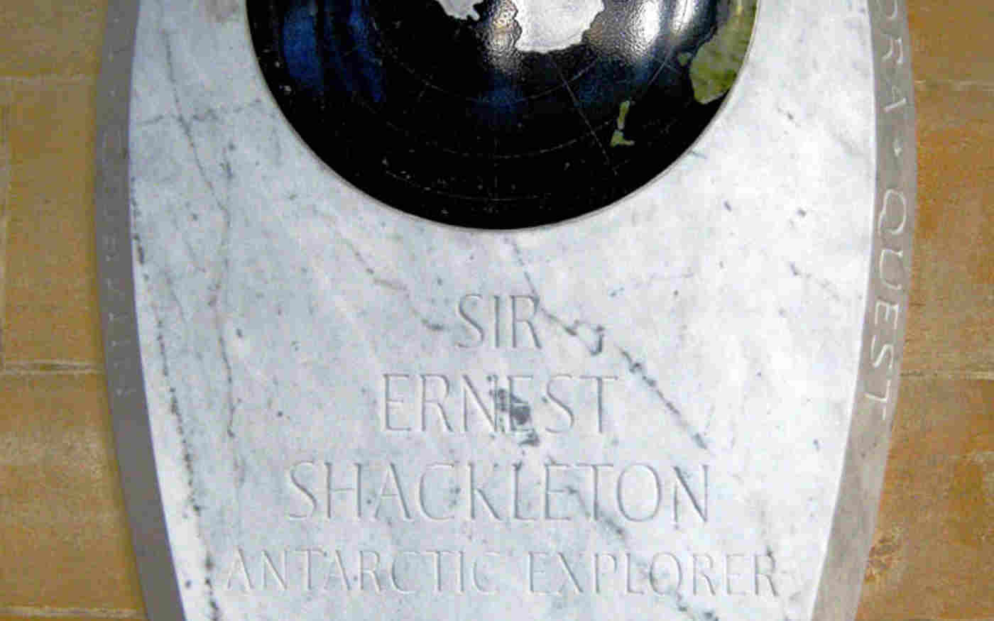 White marble memorial tablet to Sir Ernest Shackleton with circular globe showing Antarctica
