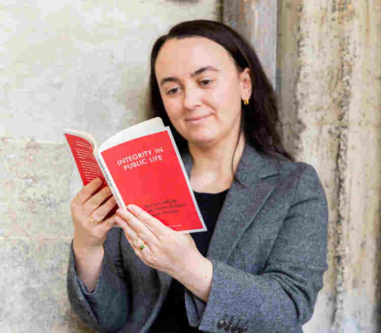 Photograph of a woman reading an Institute publication sitting in the cloisters of Westminster Abbey (C) Simon Dutson