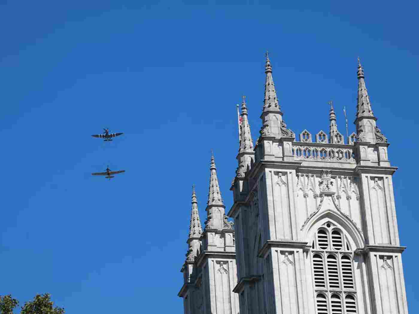 A Hurricane and a Spitfire fly over the Abbey after the service