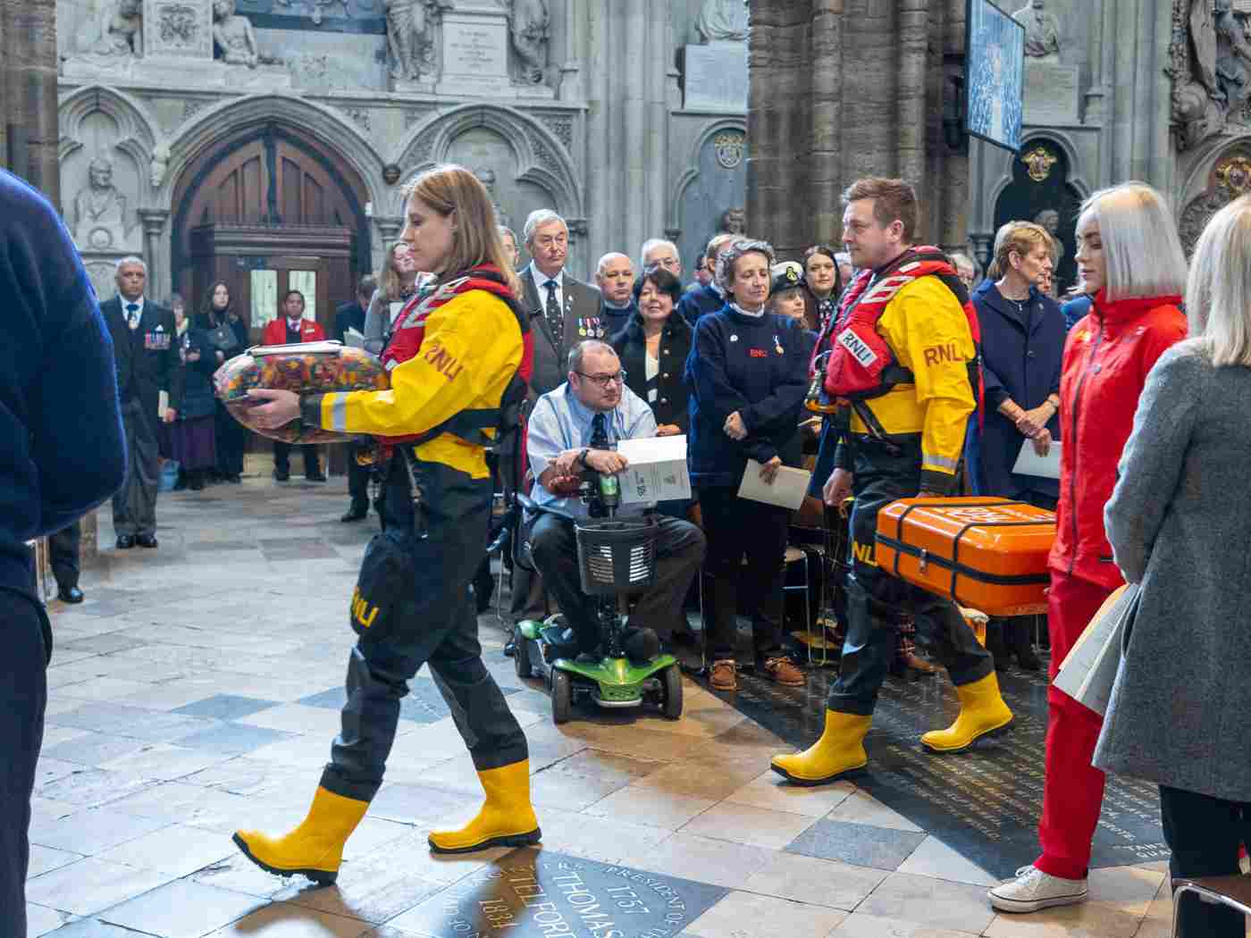 Members of the RNLI in waterproof yellow uniforms processing through the Abbey