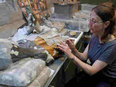 Photograph of female conservator inspecting materials within the conservation studio at Westminster Abbey