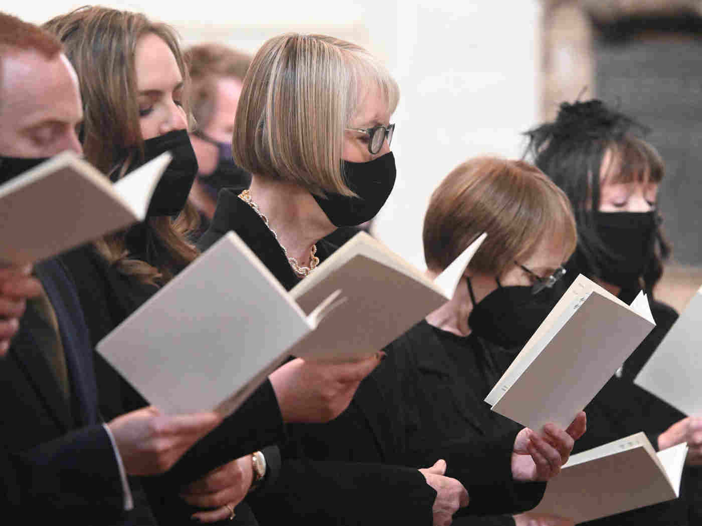 The Dromey family singing wearing black face coverings
