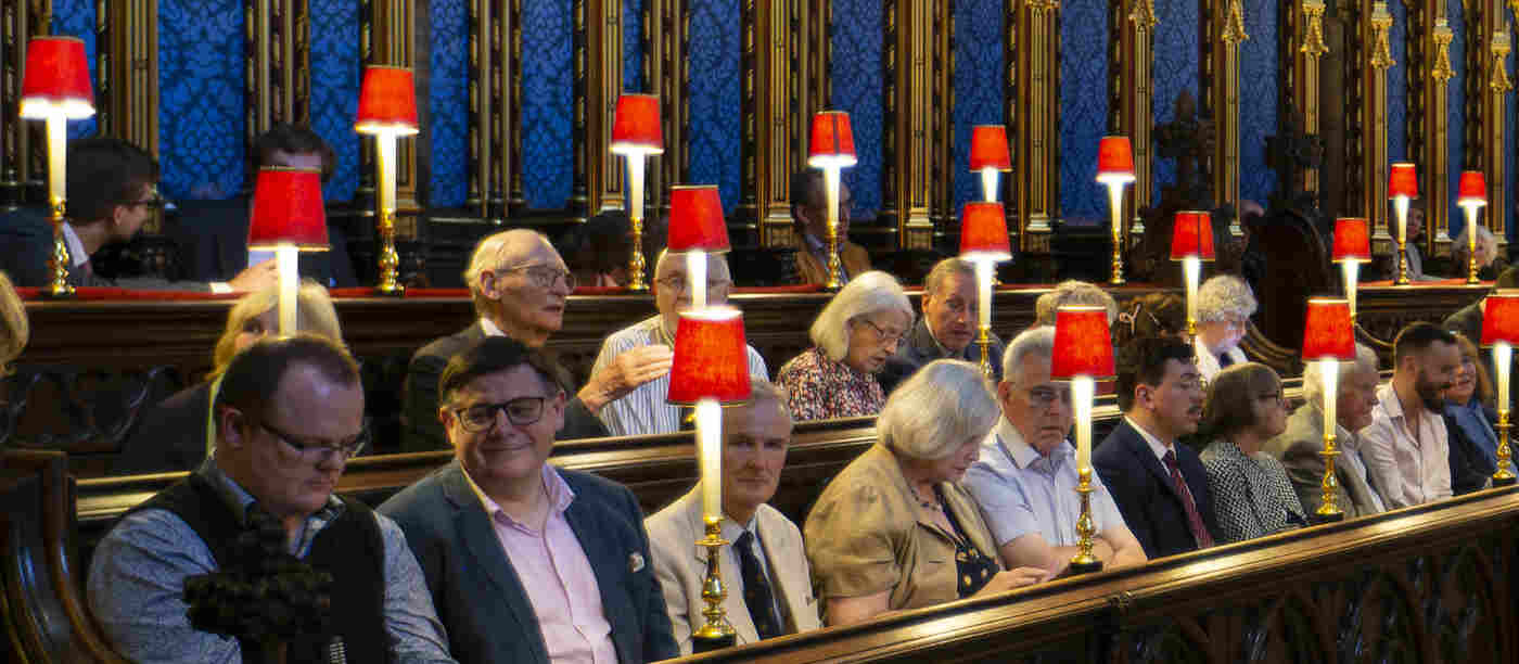 Photograph of members of the public sitting within the quire stalls of Westminster Abbey