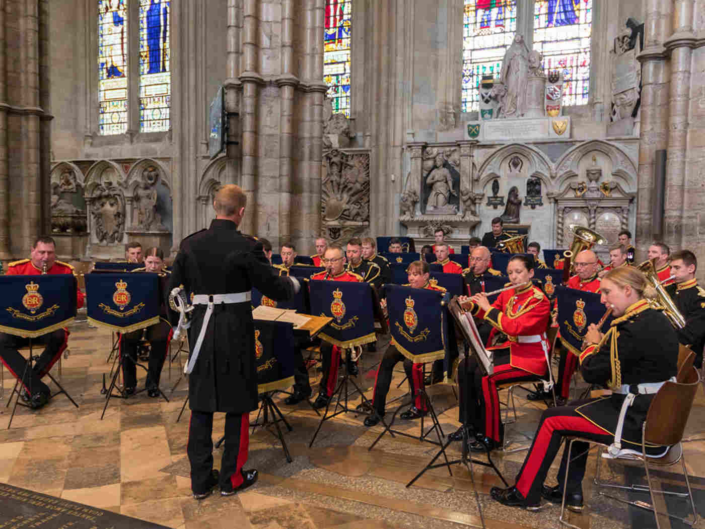 A band playing a variety of instruments being conducted