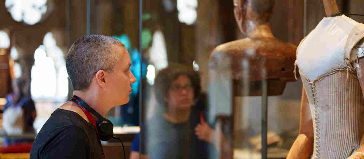 Photograph of member of the public looking at a glass case containing dressmaker's dummy within the Queen's Diamond Jubilee Galleries at Westminster Abbey