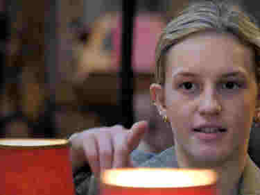 Photograph of a woman looking and pointing, with quire lamps in front of her, within Westminster Abbey