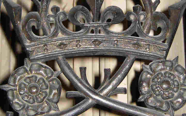 Photograph of metal gate containing Tudor roses and a crown within the Lady Chapel of Westminster Abbey