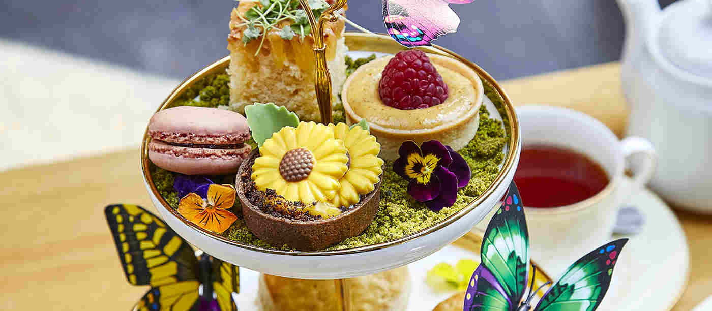 A tiered afternoon tea of scones, macarons and sandwiches