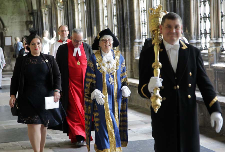 A mace bearer leads the Lord Mayor of Westminster and the Dean of Westminster through Westminster Abbey's cloisters