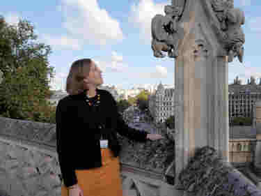 Photograph of woman standing on the roof of Westminster Abbey looking towards the Houses of Parliament