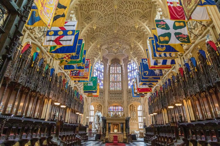 The Lady Chapel at Westminster Abbey, with its spectacular fan-vaulted ceiling, and colourful heraldic banners hanging on either side.