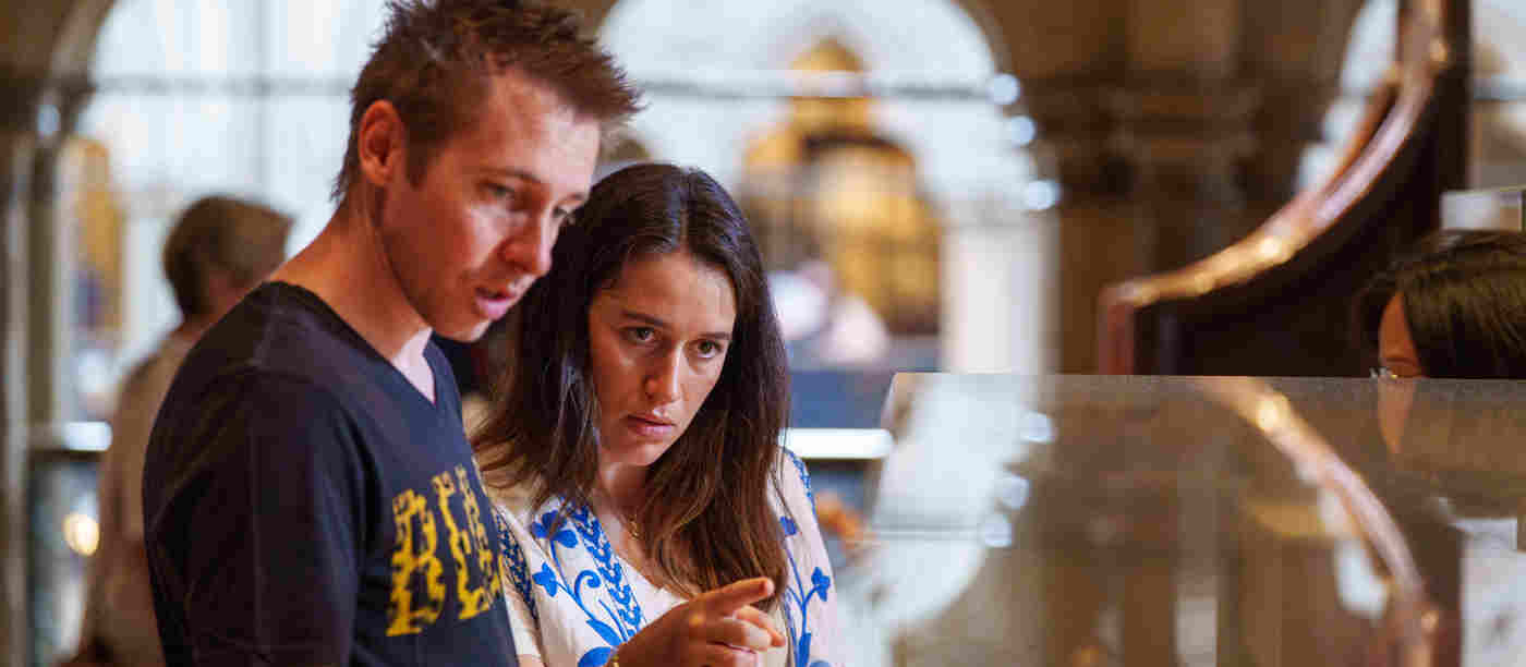 Photograph of two visitors looking at objects within the Queen's Diamond Jubilee Galleries of Westminster Abbey