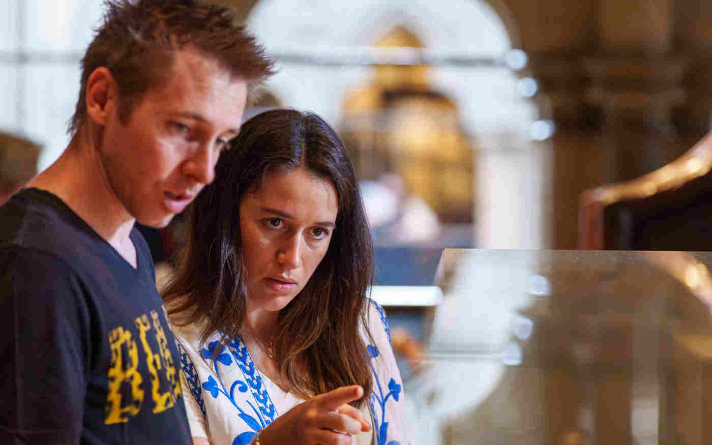 Photograph of two visitors looking at objects within the Queen's Diamond Jubilee Galleries of Westminster Abbey
