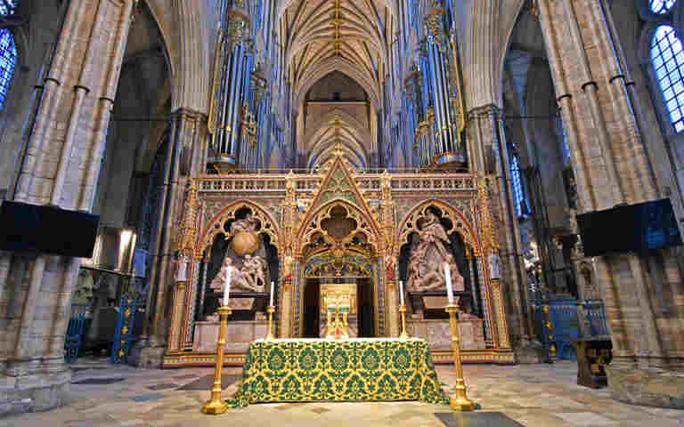 Photograph of the nave altar covered in a green altar cloth, surrounded by four candles, in front of the quire screen within an empty Westminster Abbey representing the Christian life and worship trail teachers notes
