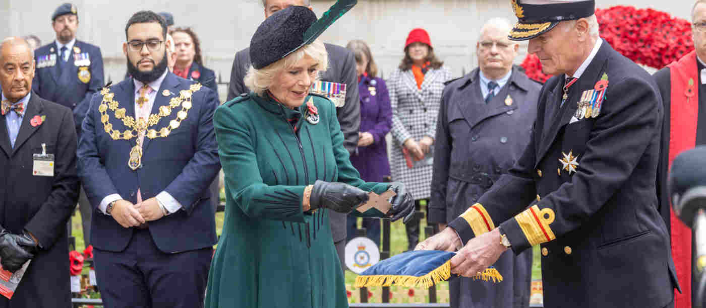 The Queen Consort receives a cross of remembrance from a member of the Armed Forces.