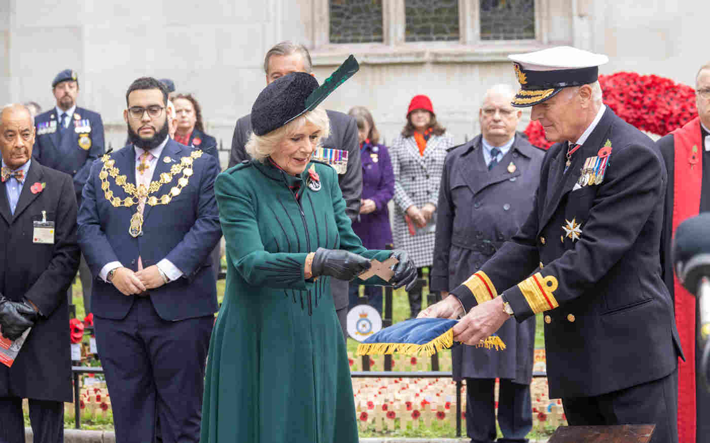 The Queen Consort receives a cross of remembrance from a member of the Armed Forces.