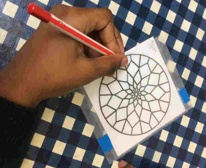 Photograph of pupil colouring during a stained glass shrinkies workshop at Westminster Abbey