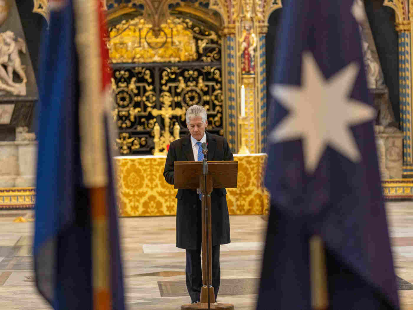 Australian High Commissioner Stephen Smith reads from a podium