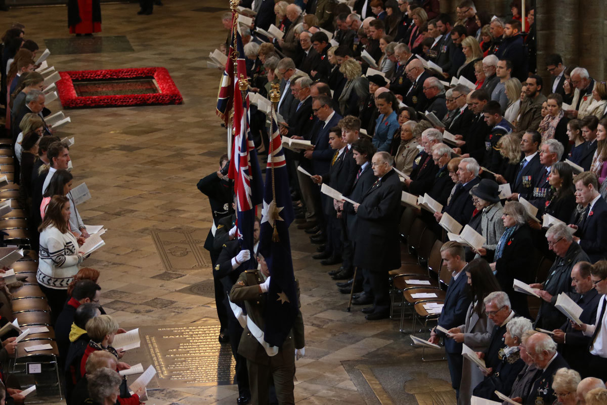 The flags of Australia, New Zealand, Turkey, and the United Kingdom are carried through the Abbey Church