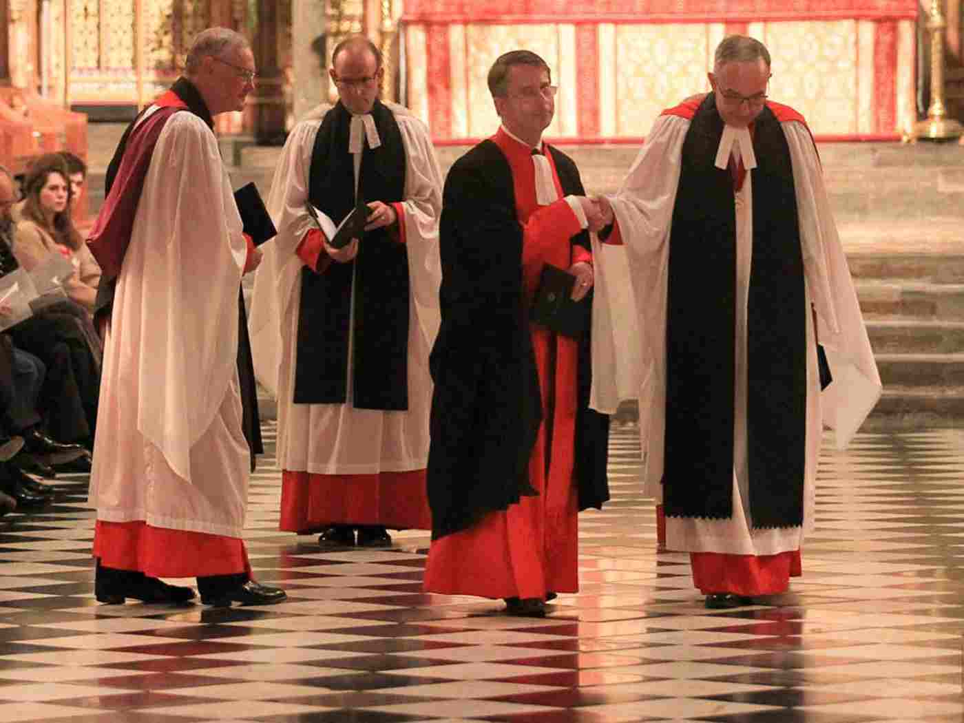 The Dean leads Paul Baumann to his stall in the Quire