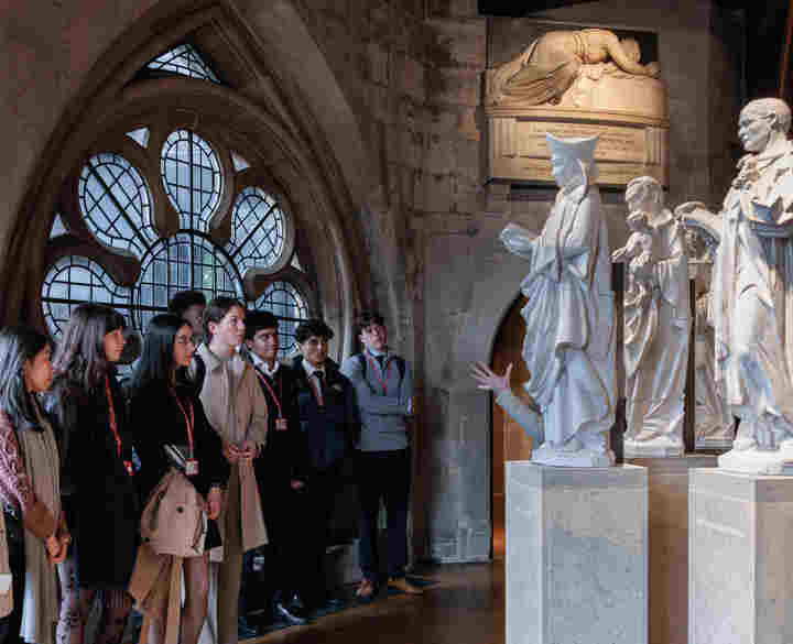 Photograph of secondary school children on a tour of the Queen's Diamond Jubilee Galleries at Westminster Abbey, looking at large maquette statues on plinths of the Modern Martyrs