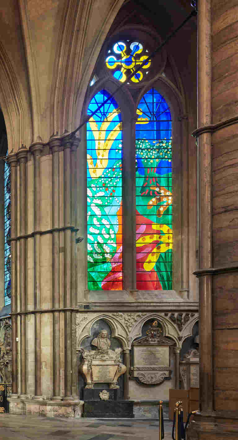 Vividly-coloured stained glass window depicting a countryside scene