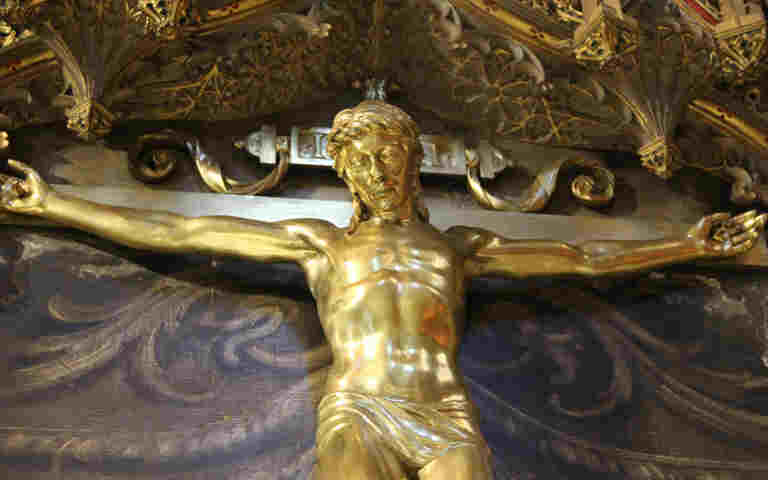 Photograph of gold crucifix, showing Jesus on the cross, within St George's Chapel of Westminster Abbey