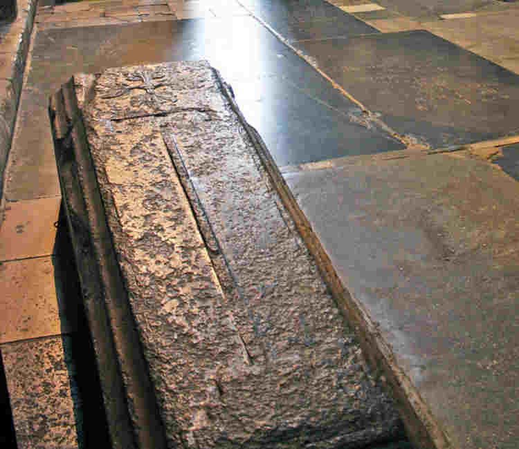 A stone coffin with a cross carved on it