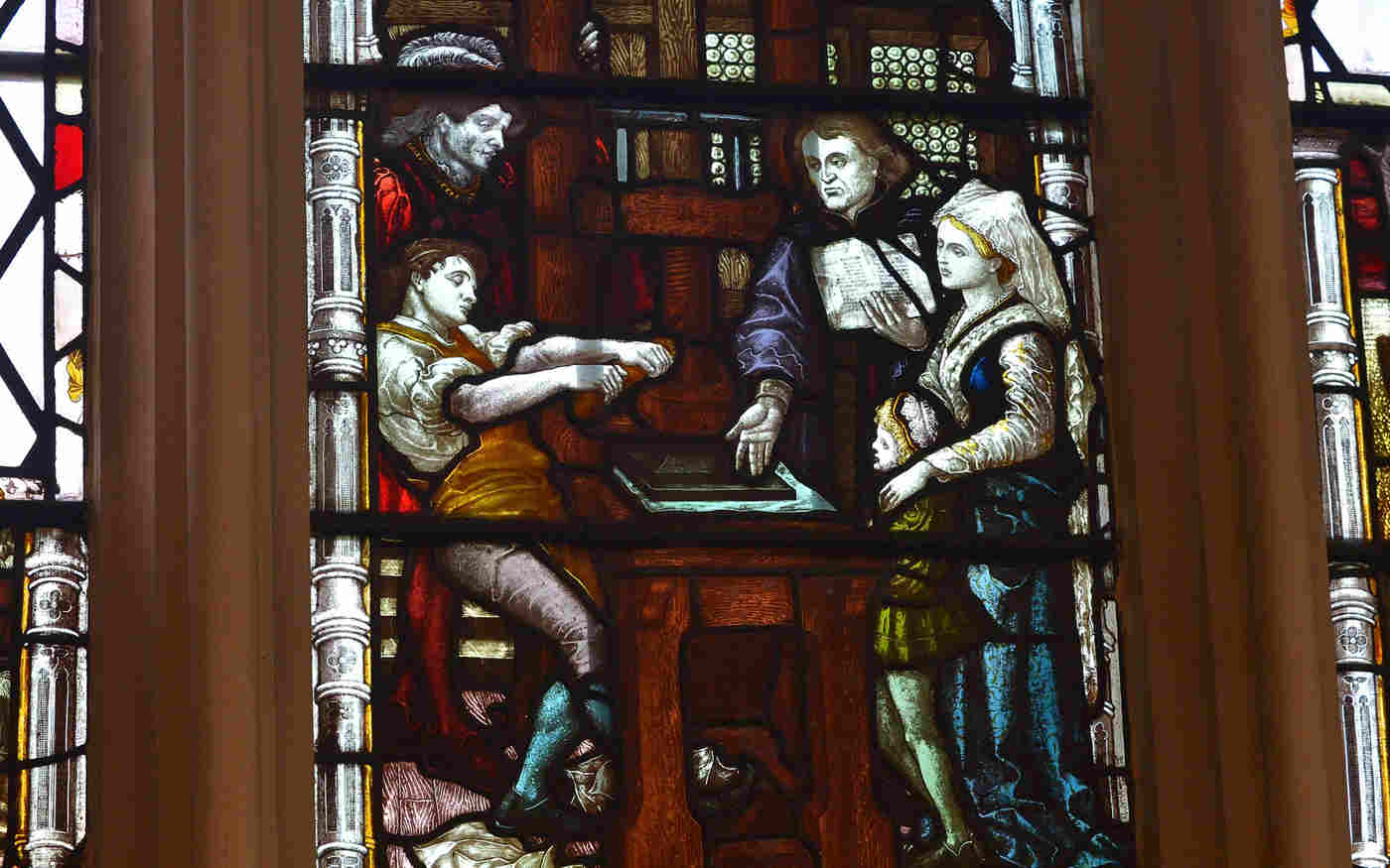 Photograph of the stained-glass window commemorating William Caxton and the printing press within St Margaret's Church, nextdoor to Westminster Abbey.