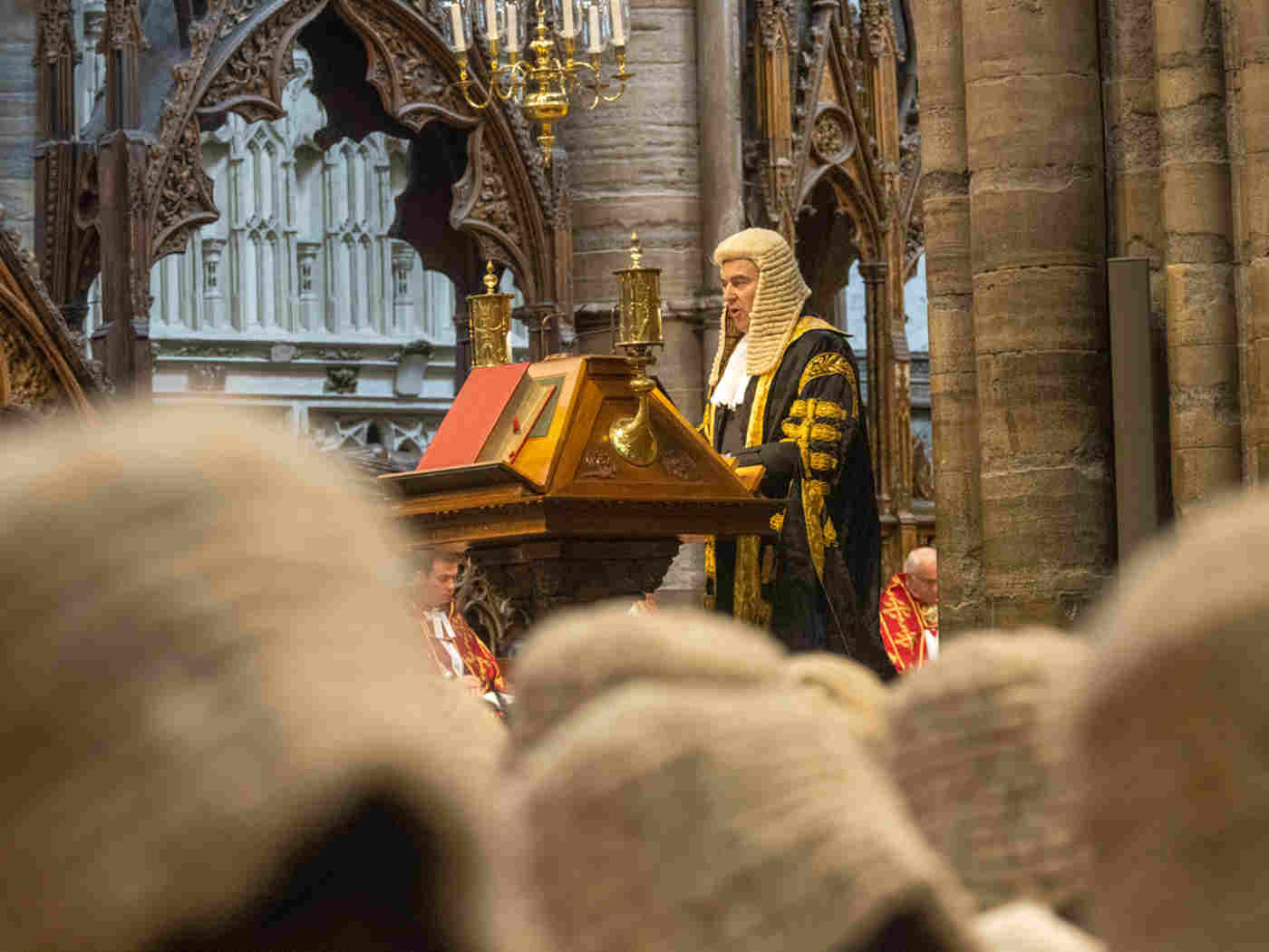 Rt Hon Brandon Lewis wearing a legal wig and reading from the lectern