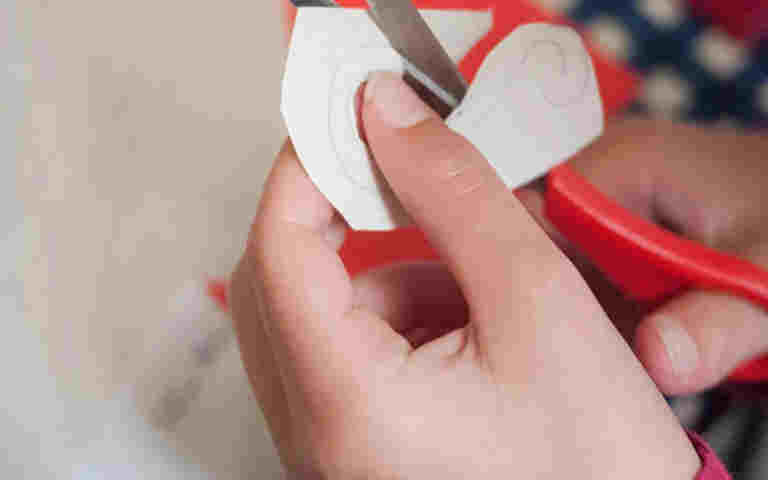 Photograph of child cutting out a shape, advertising the A to Z of Westminster Abbey activities