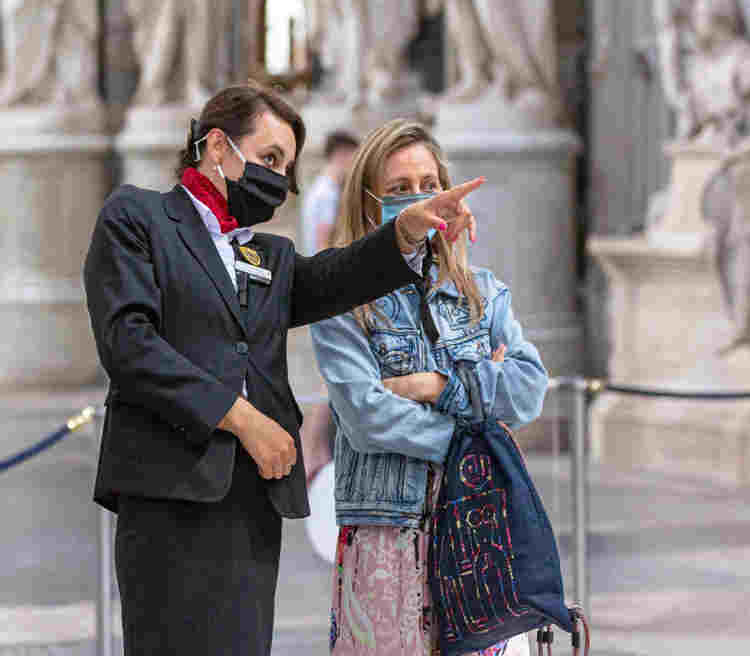 Photograph of Abbey staff talking to a visitor, both wearing masks reflecting their use during the pandemic