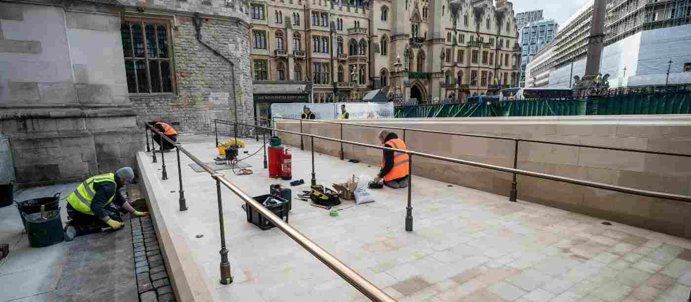 Three men in hi-vis jackets working on the new ramp outside the Abbey