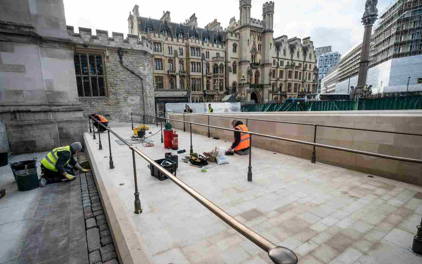 Three men in hi-vis jackets working on the new ramp outside the Abbey